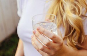 mujer toma vaso con agua