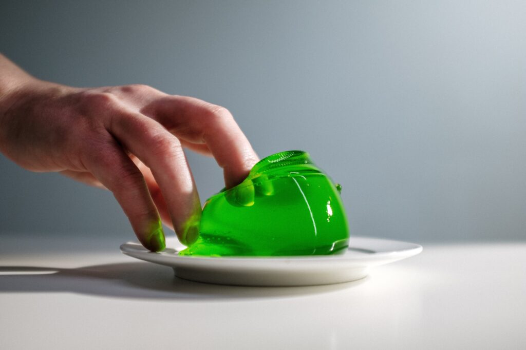 mano agarrando gelatina verde